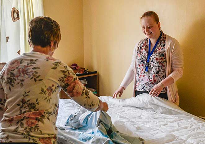 Home Carers making clients bed
