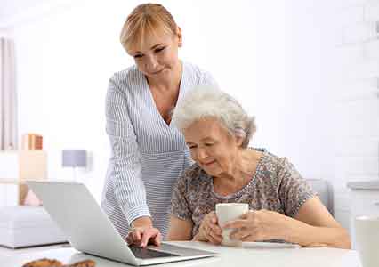carer helping lady use laptop