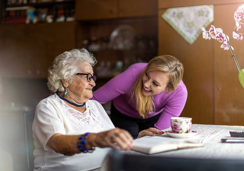 carer smiling with woman with dementia