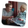 Trusted elderly caregiver laughing with client at home