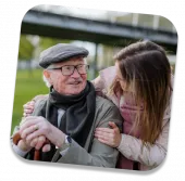 Elderly man smiling with a female carer outdoors – respite care in York supporting companionship and emotional well-being.