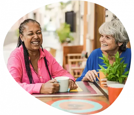 Two carers laughing while chatting about carer jobs