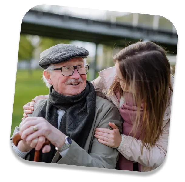 Elderly man smiling with a female carer outdoors – respite care in York supporting companionship and emotional well-being.