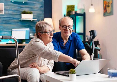 couple looking through home care questions on laptop
